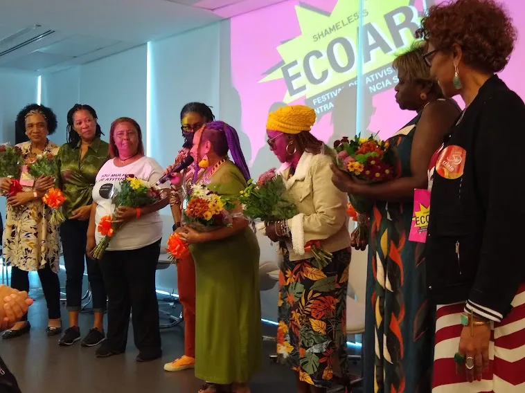 Mulheres negras com flores nas mãos durante evento no Museu de Arte do Rio